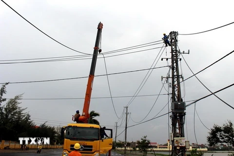 Công nhân điện lực khẩn trương khôi phục lại mạng lưới điện. (Ảnh: Thế Lập/TTXVN)