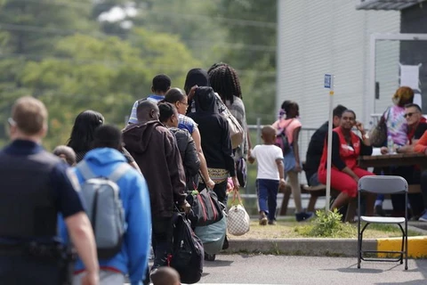 Một nhóm người xin tị nạn chờ đợi để được giải quyết sau khi được hộ tống từ trại lều của họ đến Dịch vụ Biên giới Canada ở Lacolle, Quebec, Canada. (Nguồn: reuters)