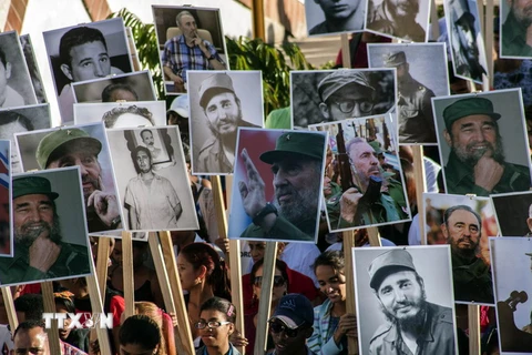 Người dân mang theo di ảnh của cố Lãnh tụ Fidel Castro tham gia lễ tuần hành tại Santiago de Cuba ngày 4/12. (Ảnh: THX/TTXVN)