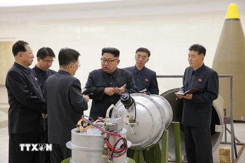 Nhà lãnh đạo Triều Tiên Kim Jong-un (thứ ba, phải) thị sát quy trình gắn đầu đạn hạt nhân thu nhỏ vào tên lửa Hwasong-14 tại Viện Khoa học hạt nhân. (Ảnh: Yonhap/TTXVN)