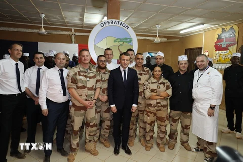 Tổng thống Pháp Emmanuel Macron (giữa) chụp ảnh với các binh sỹ Pháp trong chuyến thăm Niger. (Ảnh: AFP/TTXVN)