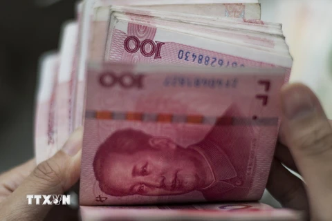 Kiểm tiền mệnh giá 100 nhân dân tệ ở Bắc Kinh. (Ảnh: AFP/TTXVN)