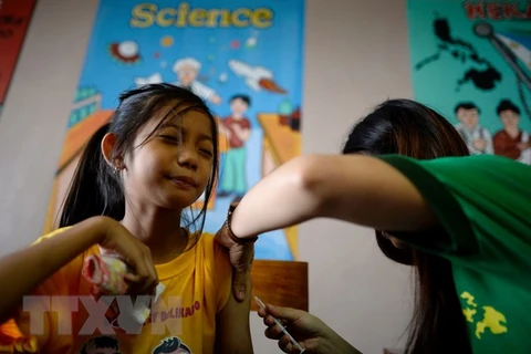 Tiêm vắcxin phòng bệnh sốt xuất huyết cho học sinh trường tiểu học Parang ở Marikina, phía tây Manila ngày 4/4. (Ảnh: AFP/TTXVN) 