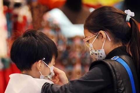 Người dân đeo khẩu trang để phòng tránh cúm tại Hong Kong, Trung Quốc. (Ảnh: AFP/TTXVN)