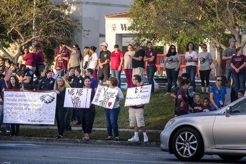 Nhiều người chào đón học sinh khi các em trở lại trường trung học Marjory Stoneman Douglas. (Nguồn: EPA)