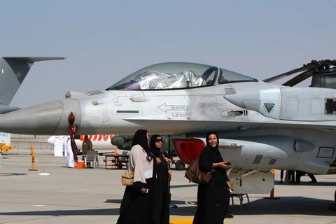 Phụ nữ đi ngang qua chiếc máy bay chiến đấu F-16 do Mỹ chế tạo được trưng bày tại Dubai Airshow. (Nguồn: AFP)