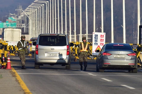 Các phương tiện đi qua trạm kiểm soát biên giới ở Paju, gần Khu phi quân sự giữa hai miền Triều Tiên để tới Khu công nghiệp chung Kaesong ngày 8/1/2016. (Ảnh: AFP/TTXVN)