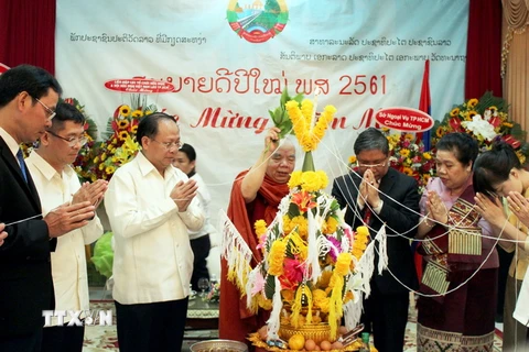 Ông Tất Thành Cang (thứ 3 từ trái sang) tham gia lễ "buộc chỉ cổ tay" cầu phúc trong năm mới truyền thống của Lào. (Ảnh: Xuân Khu/TTXVN)