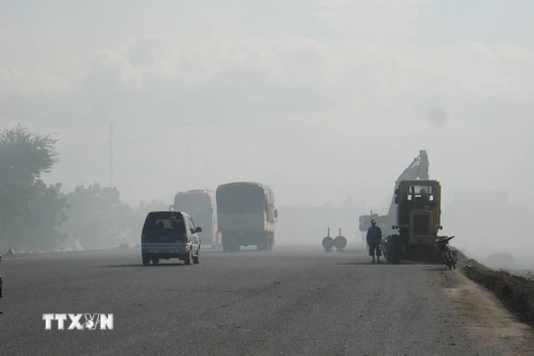 Các phương tiện tham gia giao thông trong khói bụi. (Ảnh: Công Thử/TTXVN)