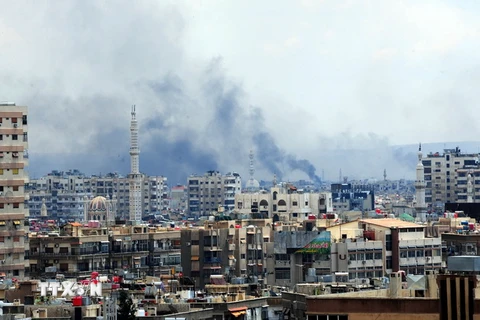 Khói bốc lên từ khu vực do phiến quân kiểm soát ở phía nam Damascus sau một cuộc oanh kích của quân đội Syria ngày 22/4 vừa qua. (Ảnh: THX/TTXVN)