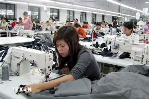 Công nhân sản xuất đồ may mặc. (Ảnh: Phạm Kiên/TTXVN)