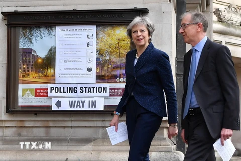 Thủ tướng Anh Theresa May (trái) và phu quân bỏ phiếu tại một địa điểm bầu cử ở London. (Ảnh: AFP/TTXVN) 