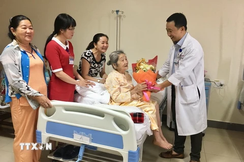 Lãnh đạo Bệnh viện Quốc tế Trung ương Huế trao tặng hoa cho cụ bà Mai Thị Song ngày xuất viện. (Ảnh: Mai Trang/TTXVN)