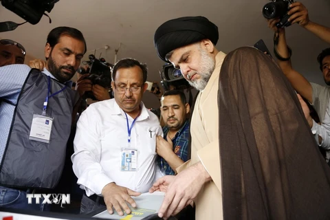 Giáo sỹ Moqtada al-Sadr (phải) bỏ phiếu tại điểm bầu cử ở Najaf, Iraq ngày 12/5 vừa qua. (Ảnh: AFP/TTXVN)
