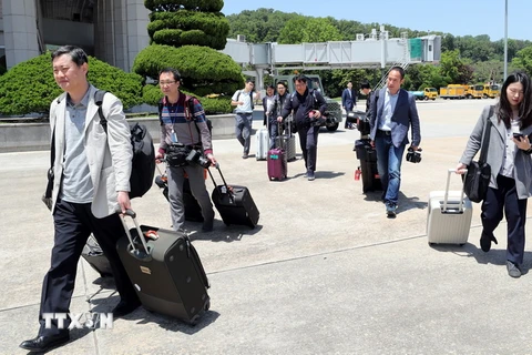 Các phóng viên Hàn Quốc lên máy bay tại sân bay ở Seongnam, đông bắc thủ đô Seoul, để tới Triều Tiên đưa tin về sự kiện dỡ bỏ bãi thử hạt nhân Punggye-ri ngày 23/5. (Ảnh: Yonhap/TTXVN)
