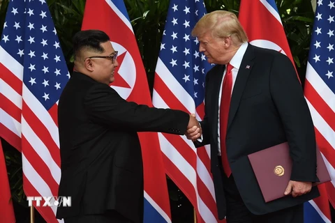 Tổng thống Mỹ Donald Trump (phải) và nhà lãnh đạo Triều Tiên Kim Jong-un (trái) trong cuộc gặp thượng đỉnh tại Singapore ngày 12/6. (Ảnh: Yonhap/TTXVN)