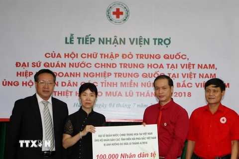 Bà Doãn Thái Hồng đại biện lâm thời Đại sứ quán Trung Quốc tại Việt Nam trao tượng trưng số tiền ủng hộ nhân dân các tỉnh miền núi phía Bắc khắc phục hậu quả mưa lũ. (Ảnh: Thanh Tùng/TTXVN)