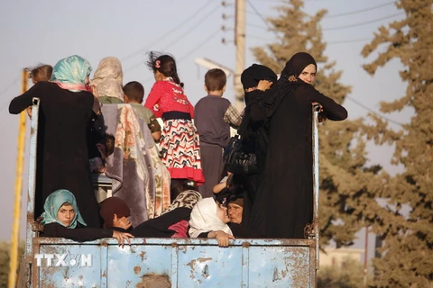 Người dân Syria trở về nhà tại khu vực ngoại ô Daraa ngày 6/7 vừa qua. (Ảnh: AFP/TTXVN)