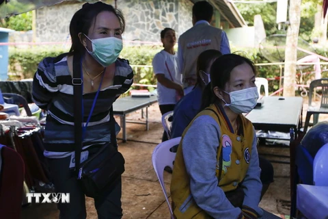 Người thân theo dõi video cung cấp hình ảnh giải cứu các thành viên đội bóng thiếu niên khỏi hang Tham Luang ngày 4/7 vừa qua. (Ảnh: EPA/TTXVN)