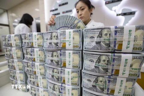 Kiểm tiền USD tại ngân hàng Hana ở thủ đô Seoul, Hàn Quốc ngày 4/7 vừa qua. (Ảnh: EPA-EFE/TTXVN)