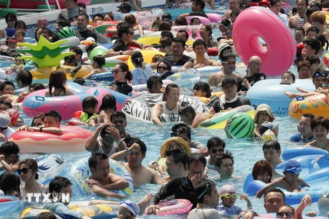 Người dân tránh nắng nóng tại bể bơi trong công viên ở thủ đô Tokyo, Nhật Bản ngày 16/7 vừa qua. (Ảnh: EPA/TTXVN)