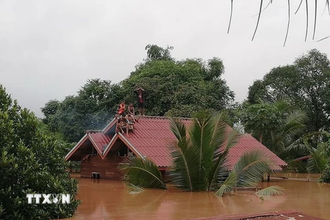 Người dân chờ cứu hộ tại vùng ngập lụt do sự cố vỡ đập thủy điện Xe Pian-Xe Namnoy ở Attapeu ngày 24/7. (Ảnh: THX/TTXVN)