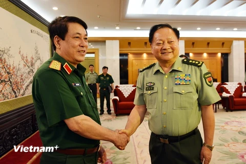 Thượng tướng Lương Cường và Phó chủ tịch Quân ủy Trung ương Trung Quốc Trương Hựu Hiệp bắt tay thân mật. (Ảnh: Lương Tuấn/Vietnam+)