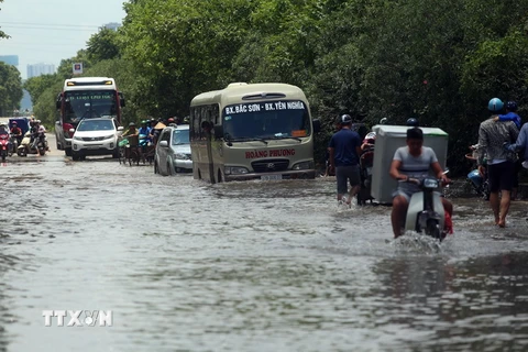 Đoạn đường Đại lộ Thăng Long gần khu đô thị đô thị An Khánh, huyện Hoài Đức, Hà Nội, vẫn bị ngập sâu, phương tiện đi lại gặp nhiều khó khăn. (Ảnh: Huy Hùng/TTXVN)