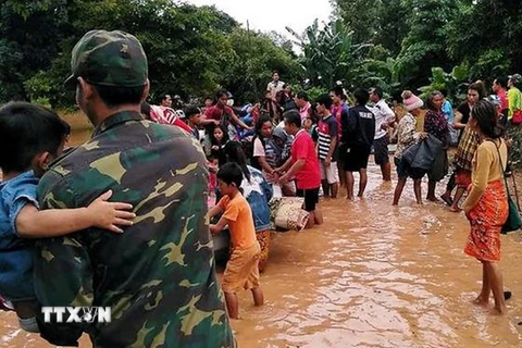 Người dân sơ tán khỏi các khu vực ngập lụt sau sự cố vỡ đập thủy điện Sapien. (Ảnh: Reuters/TTXVN)