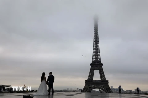  Một cặp đôi chụp ảnh cưới tại khu vực Tháp Eiffel ở Paris. (Ảnh: AFP/TTXVN)