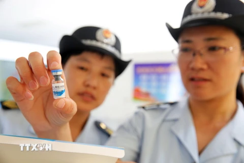 Nhân viên Tổng cục Giám sát và quản lý thực phẩm và dược phẩm quốc gia Trung Quốc kiểm tra vắcxin tại Hoài Bắc, An Huy ngày 24/7 vừa qua. (Ảnh: AFP/TTXVN)