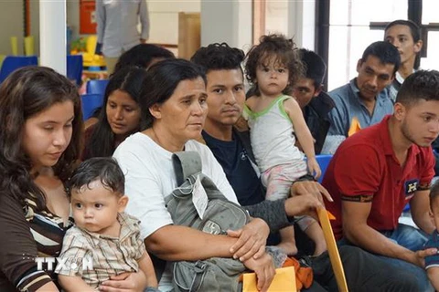 Trong ảnh: Người nhập cư chờ được hỗ trợ tại một trung tâm nhân đạo ở thị trấn McAllen, bang Texas, Mỹ ngày 14/6 vừa qua. (Ảnh: AFP/TTXVN)