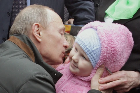 Thủ tướng Nga Vladimir Putin hôn một em bé ở St. Petersburg. (Nguồn: AFP/Getty Images)