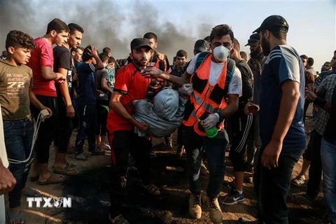 Nhân viên y tế Palestine chuyển người biểu tình bị thương trong xung đột với binh sỹ Israel tại khu vực biên giới Dải Gaza ngày 28/9. (Ảnh: THX/TTXVN)