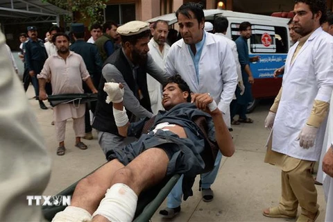 Chuyển nạn nhân bi thương tại hiện trường vụ đánh bom liều chết ở tỉnh Nangarhar ngày 2/10. (Ảnh: AFP/TTXVN)