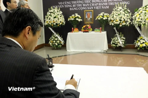 Đại sứ Phạm Vinh Quang viết sổ tang sau lễ viếng (Ảnh: Hải Ngọc/Vietnam+)