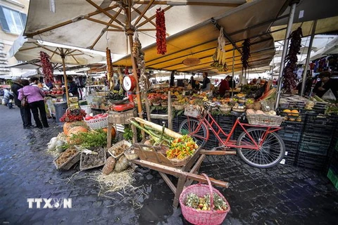 Người dân mua sắm tại một khu chợ ở Rome của Italy. (Ảnh: AFP/TTXVN)
