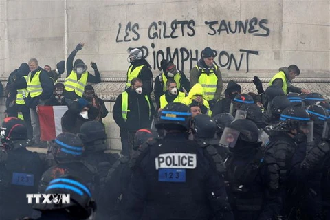 Cảnh sát chống bạo động được triển khai nhằm đối phó với người biểu tình "Áo vàng" gây bạo loạn tại Paris. (Ảnh: AFP/TTXVN)