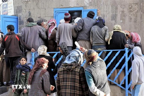 Người dân xếp hàng đợi nhận khẩu phần ăn tại một trung tâm cứu trợ ở thủ đô Sanaa của Yemen. (Ảnh: THX/TTXVN)