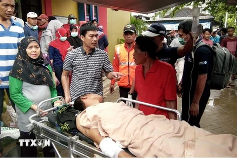 Chuyển nạn nhân bị thương sau thảm họa sóng thần tới bệnh viện ở Carita, Indonesia ngày 23/12. (Ảnh: AFP/TTXVN)