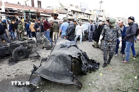 Lực lượng an ninh Iraq điều tra tại hiện trường một vụ đánh bom ở Iraq. (Ảnh: AFP/TTXVN)