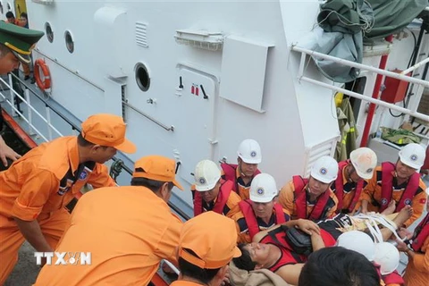 Nhân viên Trung tâm Phối hợp tìm kiếm, cứu nạn Hàng hải Khu vực 4 đưa nạn nhân bị thương từ tàu cứu nạn SAR 27-01 lên bờ. (Ảnh: Phan Sáu/TTXVN) 