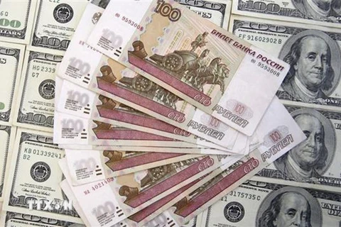 Đồng Ruble của Nga (phía trên) và đồng USD. (Ảnh: Reuters/TTXVN)