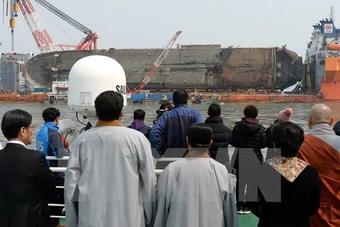 Thân nhân các nạn nhân trong vụ chìm phà Sewol theo dõi quá trình trục vớt ở ngoài khơi đảo Jindo, Hàn Quốc ngày 28/3/2017. (Ảnh: EPA/TTXVN)