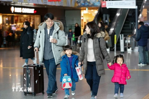 Một gia đình chờ tàu tại nhà ga Seoul của Hàn Quốc để về nhà ăn Tết Nguyên đán, ngày 2/2 vừa qua. (Ảnh: Yonhap/TTXVN)