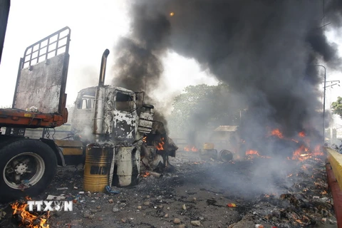 Xe tải chở hàng nhân đạo bị đốt tại khu vực biên giới giữa Venezuela và Colombia ngày 23/2. (Ảnh: AFP/TTXVN)