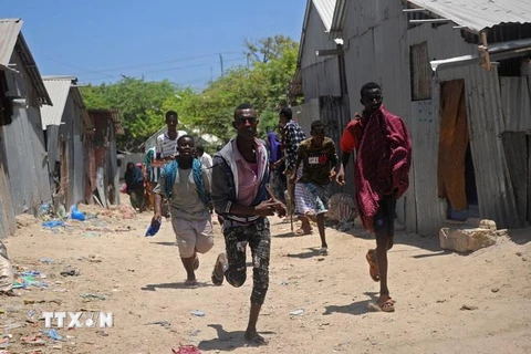 Người dân sơ tán khỏi hiện trường vụ tấn công ở Mogadishu của Somalia, ngày 23/3 vừa qua. (Ảnh: AFP/TTXVN)