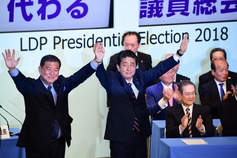 Thủ tướng Nhật Bản Shinzo Abe (giữa) chia vui cùng các thành viên Đảng LDP sau khi ông tái đắc cử chức Chủ tịch đảng tại Tokyo. (Ảnh: AFP/TTXVN)