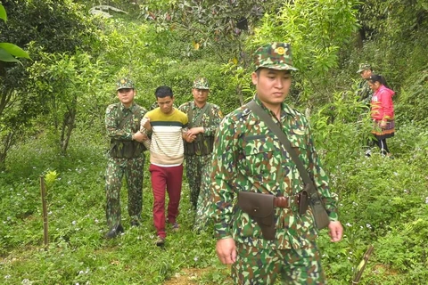 Lực lượng biên phòng áp giải đối tượng Ly Seo Ca tại khu vực biên giới. (Ảnh: TTXVN)