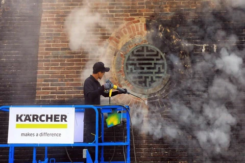 Các chuyên gia Karcher làm sạch di tích cổng Ngọ Môn, Đại nội Huế bằng công nghệ hơi nước nóng. (Ảnh: Quốc Việt/TTXVN)